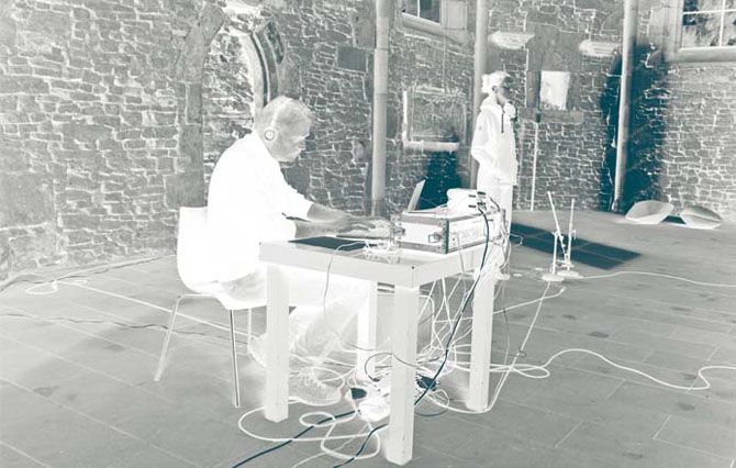 Negativbild Mann mit Kopfhörern sitzt an Tisch und bedient Audioequipment