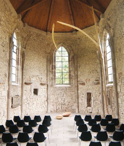 Weizenblatt schwebt an stilisiertem, raumhohen Weizenhalm aus Holz in der Wintringer Kapelle