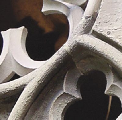 Detailaufnahme eines steinernen Maßwerks mit geschwungenen, gotischen Formen und Durchbrüchen