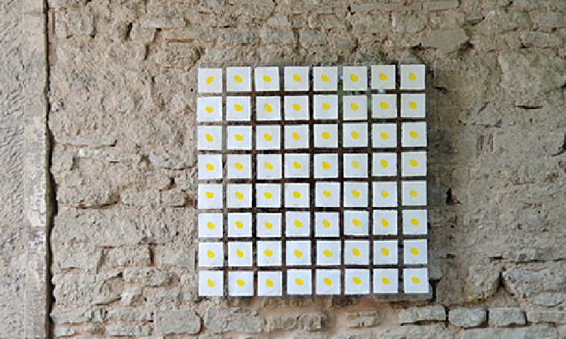 64 quadratische, mit einem gelben Punkt bestempelte Papierkärtchen